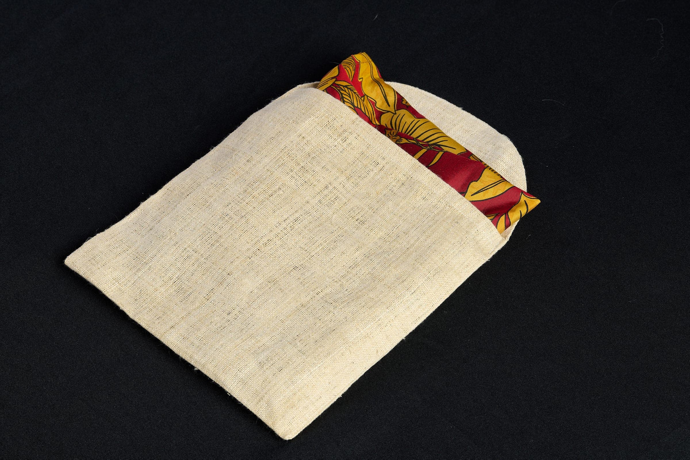 The Heritage Hemp Pochette in natural hand-loomed hemp, with a silk scarf folded inside