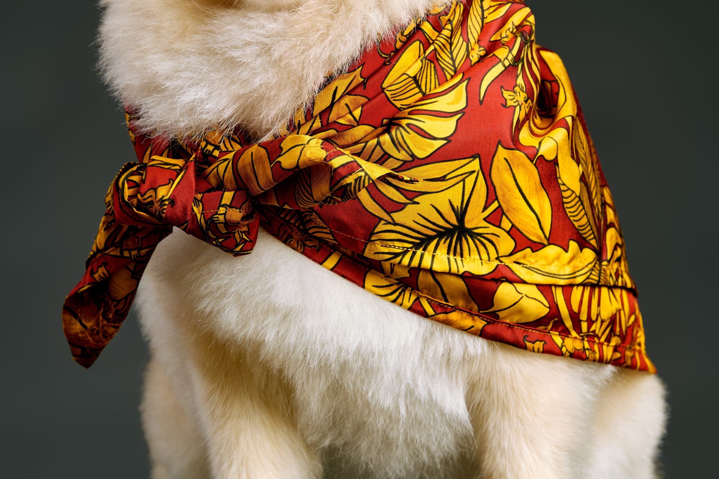 Close detail of the hand-rolled hem and knot of the Golden Palms silk scarf